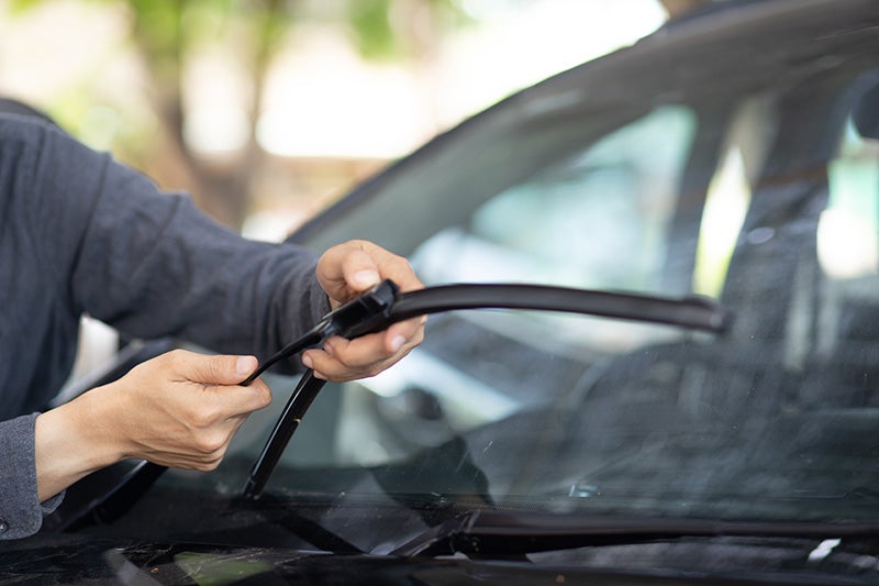 man cleaning windshield wiper